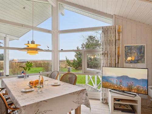 a dining room with a table and a large window at Holiday Home Hjalmine - 225m from the sea by Interhome in Gørlev
