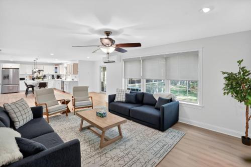 a living room with two couches and a table at Gray Woodland Escape Golf, Pool & Cinema home in Gray