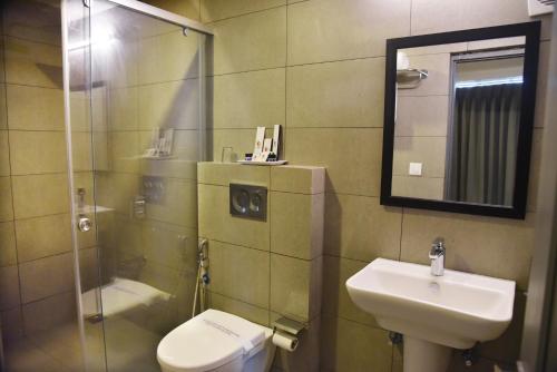 a bathroom with a sink and a toilet and a mirror at Ginger Ahmedabad RTO Circle in Ahmedabad