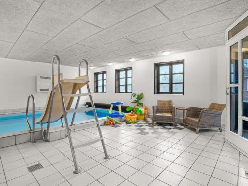 a room with a pool with a slide and chairs at Holiday Home Star - 200m to the fjord by Interhome in Farsø