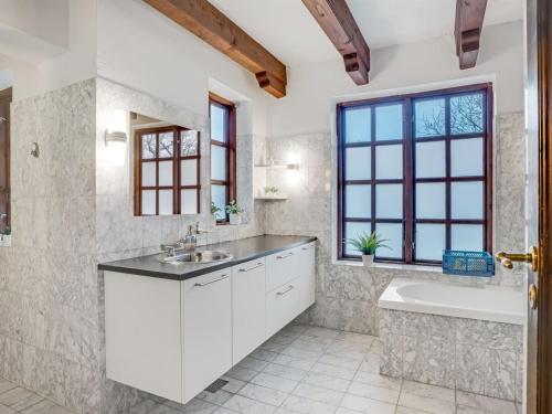 a white bathroom with a tub and a sink and a bath tubermott at Holiday Home Star - 200m to the fjord by Interhome in Farsø