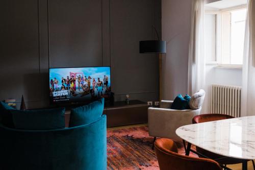 a living room with a tv and a table and chairs at Al Duomo in centro città in Perugia