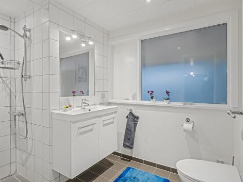a bathroom with a sink and a toilet and a window at Holiday Home Sven - 250m to the fjord by Interhome in Højslev