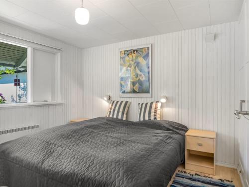 a bedroom with a bed and a painting on the wall at Holiday Home Sven - 250m to the fjord by Interhome in Højslev
