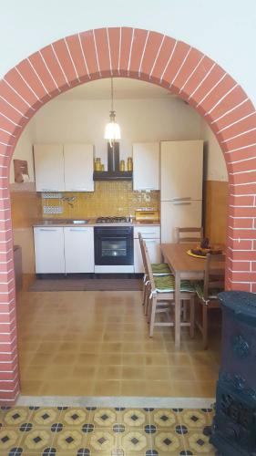 a kitchen with an archway with a table and appliances at L'Angolo con vista a Bajardo in Berzi
