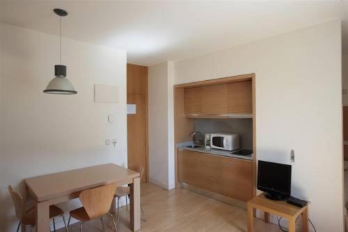 a living room with a table and a kitchen at Casa de los Beneficiados in Roncesvalles