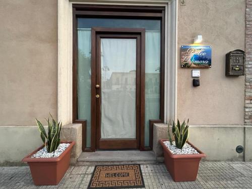 two potted plants sitting in front of a door at Dolce Dimora in Milazzo