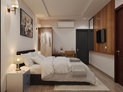 a bedroom with a bed with white sheets and a television at Luxury Hotel Saigon in Ho Chi Minh City