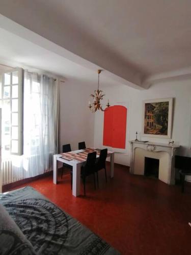 a dining room with a table and a fireplace at Appartement 1er étage in Castellane