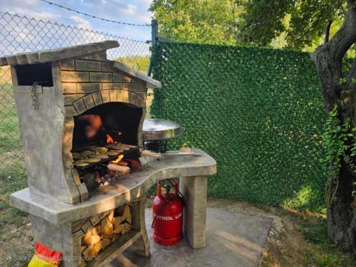 a stone oven with a fire hydrant next to a fence at Violeta guest house in Petrovaradin