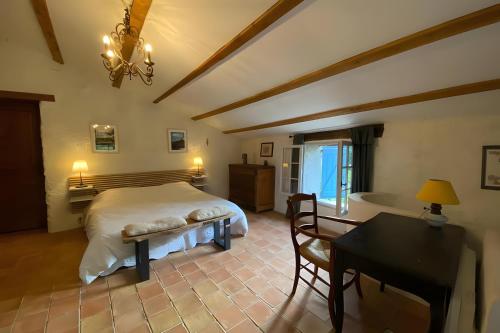 a bedroom with a bed and a desk and a tub at Maison en Provence ancien moulin in Entrepierres
