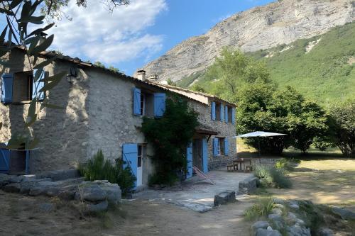 a stone house with a mountain in the background at Maison en Provence ancien moulin in Entrepierres