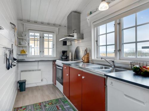 a kitchen with a sink and two windows at Holiday Home Ung - 650m to the fjord by Interhome in Struer