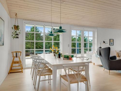 a dining room and living room with a white table and chairs at Holiday Home Toska - 3km from the sea by Interhome in Blokhus