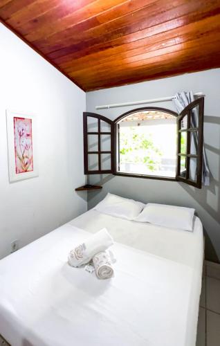 a bedroom with two beds and a window at Pousada Flora Búzios in Búzios