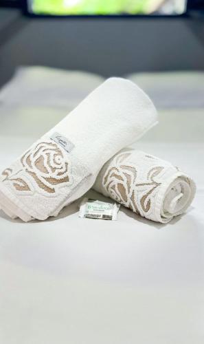 a roll of toilet paper sitting on a bed at Pousada Flora Búzios in Búzios