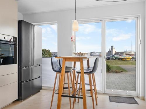 a kitchen with a table with chairs and a refrigerator at Holiday Home Claudine - 90m from the sea by Interhome in Assens