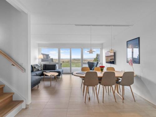 a dining room and living room with a table and chairs at Holiday Home Claudine - 90m from the sea by Interhome in Assens