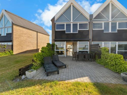 a house with a patio in front of it at Holiday Home Claudine - 90m from the sea by Interhome in Assens