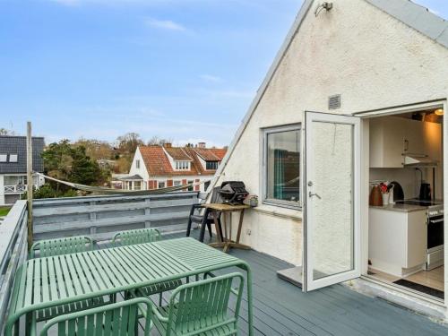 a balcony with a green bench and an open door at Apartment Drude - 50m from the sea by Interhome in Allinge