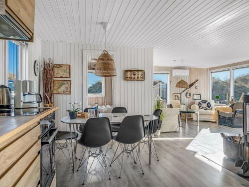a kitchen and living room with a table and chairs at Holiday Home Alrike - 200m from the sea by Interhome in Brovst