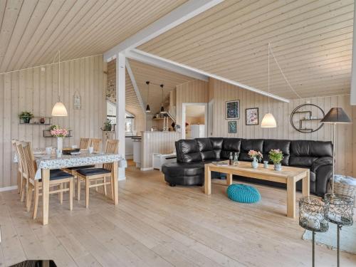 a living room with a black leather couch and a table at Holiday Home Antero - 500m to the fjord by Interhome in Spottrup