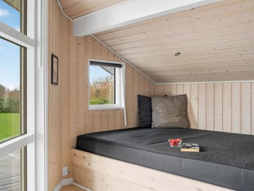 a bed in a tiny house with a window at Holiday Home Antero - 500m to the fjord by Interhome in Spottrup