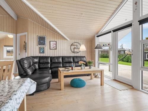 a living room with a leather couch and a table at Holiday Home Antero - 500m to the fjord by Interhome in Spottrup