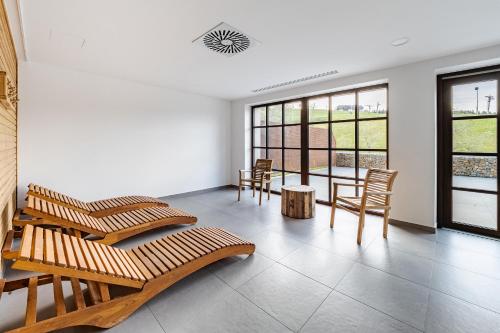 a room with chairs and a table and windows at Wellness apartmán Pila Kvilda in Kvilda