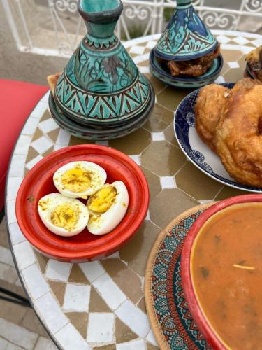 a table with eggs on a plate on a table at Riad Serendipity in Fès