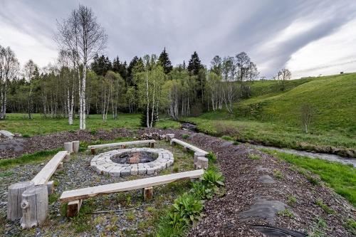 a park with a bench and a fire pit at Wellness apartmán Pila Kvilda in Kvilda