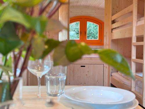ゲッティンゲンにあるFerienhauspark im Freibad Brauweg - Rolling Lodgesの木製の小屋の上に皿とグラスが置かれたテーブル