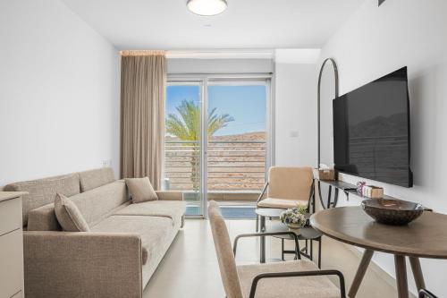 a living room with a couch and a table at Yalarent Amazing apartments U360 Complex Eilat in Eilat