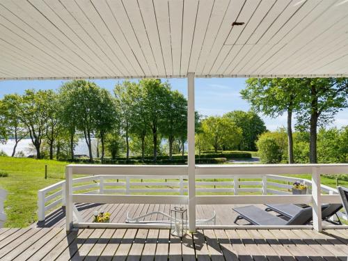 a white umbrella on a deck with chairs under it at Holiday Home Conradine - 600m from the sea by Interhome in Kruså