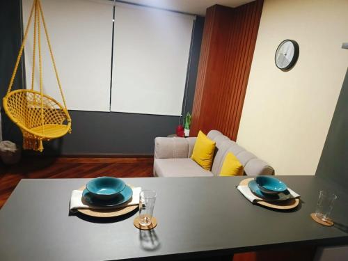 a table with two hats and plates on it in a living room at Suites SION in Ambato
