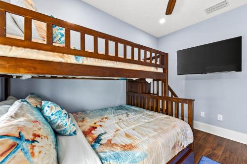 a bedroom with two bunk beds and a flat screen tv at Blue Pearl in Coffeyville