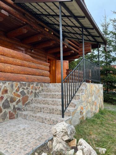 a house with a stone staircase and a wooden building at Artem Chalet in Ciocanu