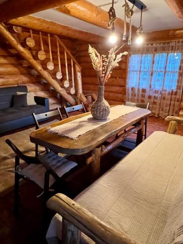 a dining room with a wooden table and a vase on it at Artem Chalet in Ciocanu