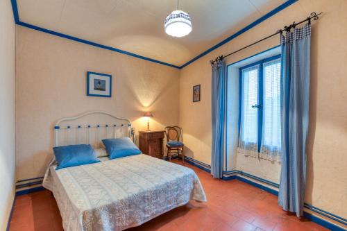 une chambre avec un lit et une grande fenêtre dans l'établissement La Coustouline, à Lacoste