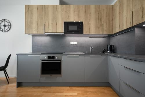 a kitchen with a stove and a sink and a microwave at Modern Stylish Apartment with Private Garage in Prague