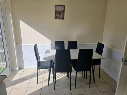 a dining room with a white table and chairs at Gorgeous 3 bed House - Free Parking near Elizabeth line in Abbey Wood