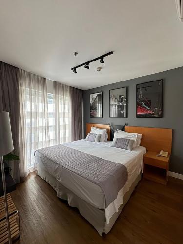 a bedroom with a large bed and a large window at Get a Flat 405 Noble-Jardins Neighborhood - SP in Sao Paulo