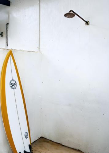 a surfboard leaned up against a wall with a pole at Woodlands Beach Villa in Southbroom