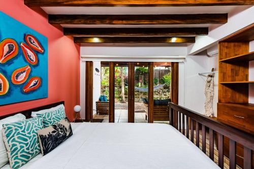 a bedroom with a bed and a balcony at Hidden Oasis Across The Street From The Beach in Tamarindo