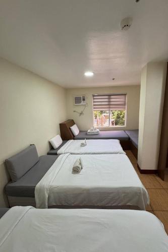 a bedroom with two beds and a window at I'm Inn Hotel Sorsogon near SM or Terminal in Sorsogon