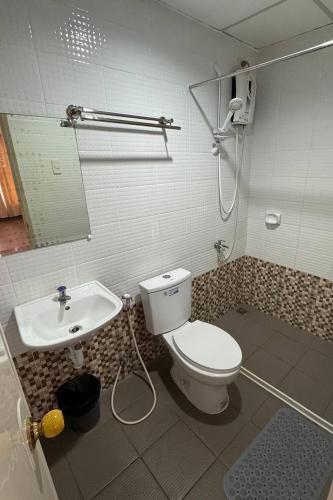 a bathroom with a toilet and a sink at I'm Inn Hotel Sorsogon near SM or Terminal in Sorsogon