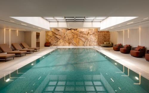 a large swimming pool in a hotel with chairs at Yalarent Amazing apartments U360 Complex Eilat in Eilat