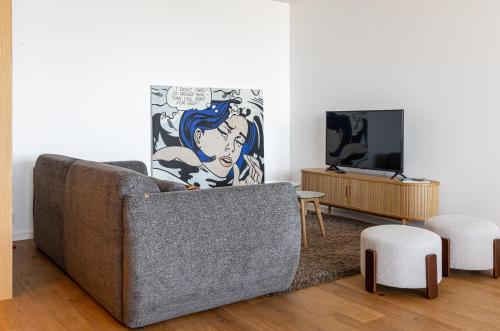 a living room with a couch and a tv at Bellevue | Sea & River View | Garage in Canidelo