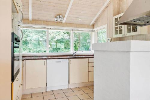 a kitchen with white cabinets and a large window at 80608-Vemb-Knudehus-51 in Lillelund