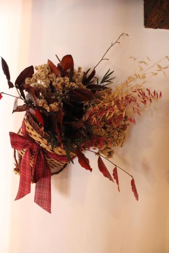 a basket of dried flowers hanging on a wall at Giuliva B&B in Refrontolo